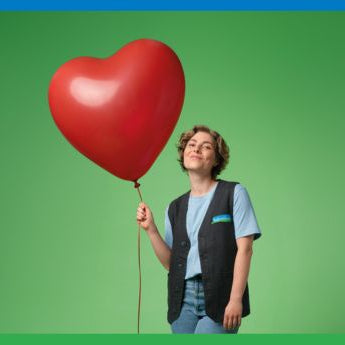 Reformhaus Beraterin mit rotem, herzförmigem Luftballon in der Hand